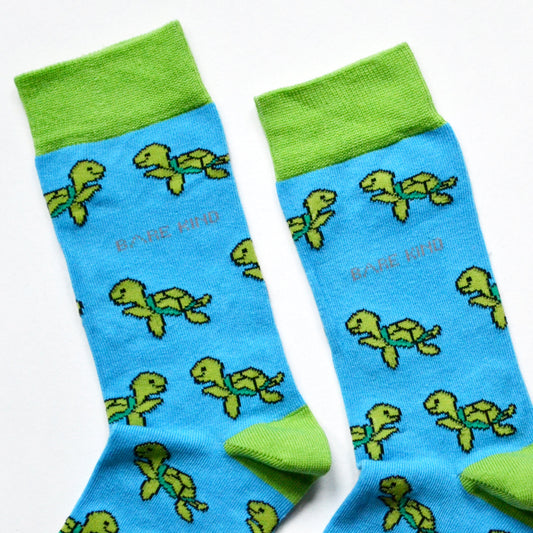 Sky blue bamboo socks with animated green turtles, supporting turtle conservation.