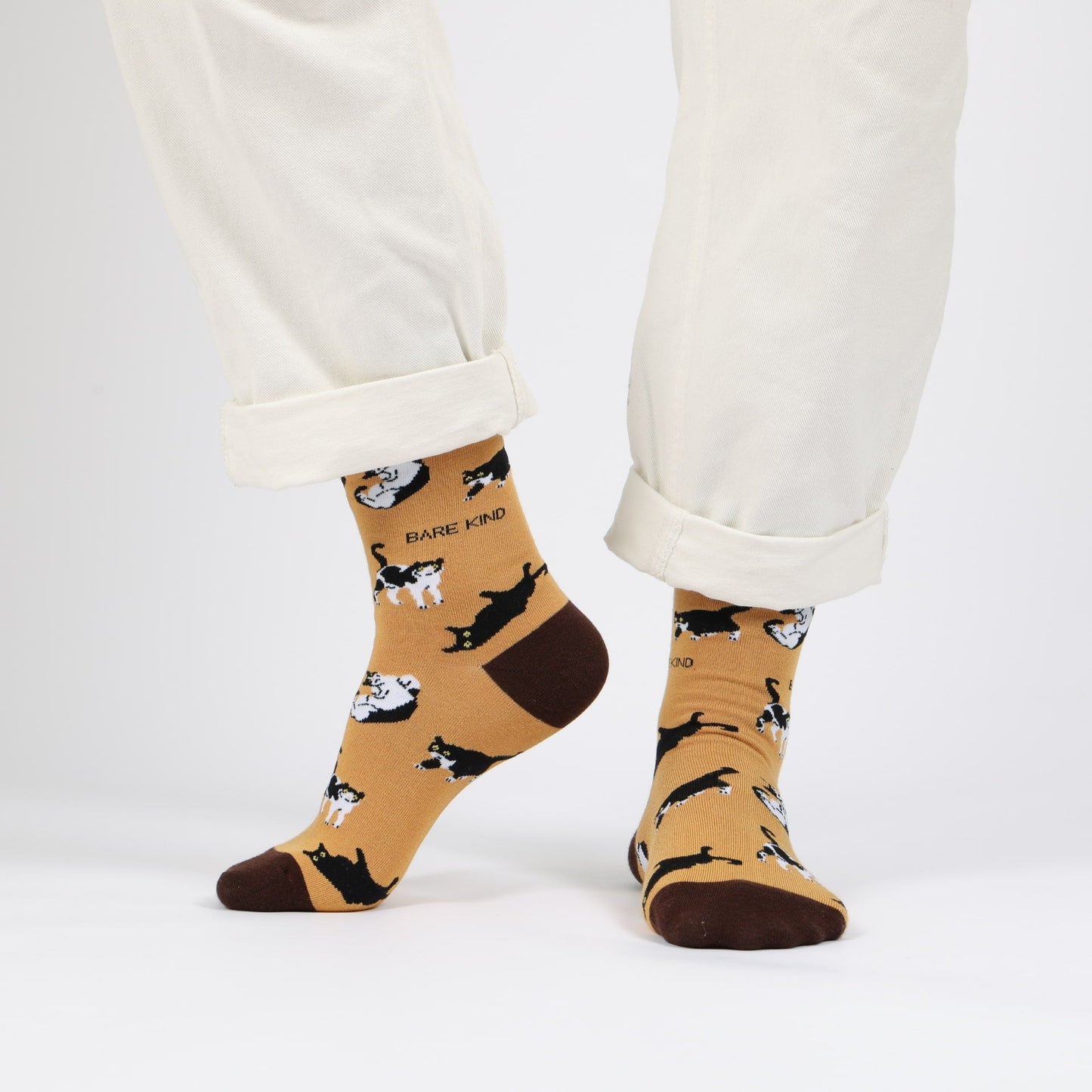 model with white trousers wearing yellow brown cat bamboo socks