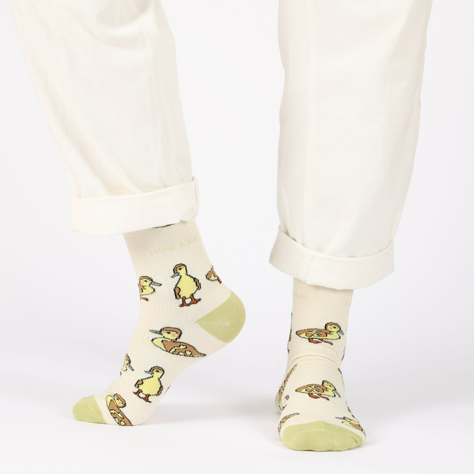 model with white trousers wearing green ducklings bamboo socks