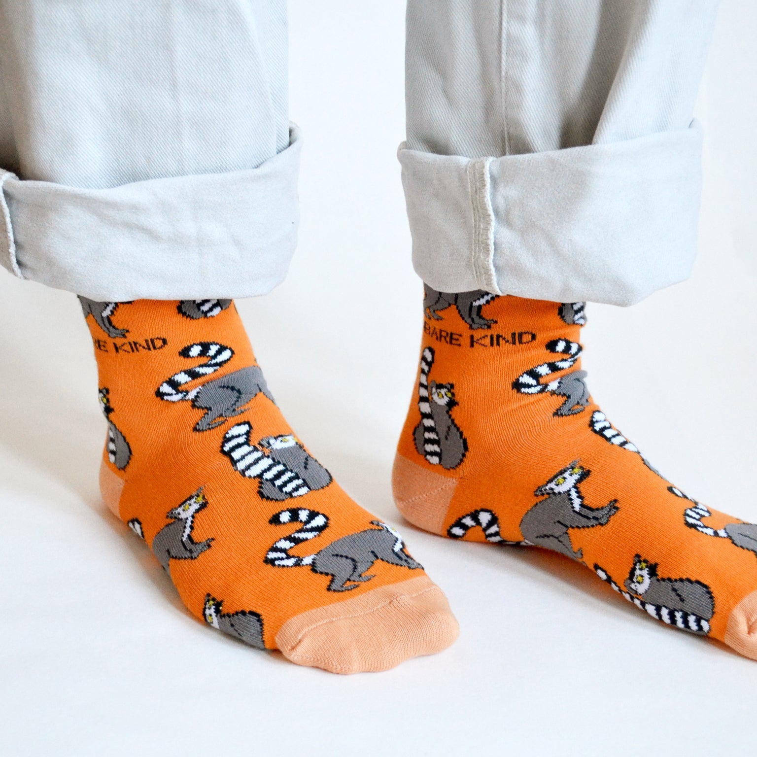 closeup of orange lemur socks on standing model 