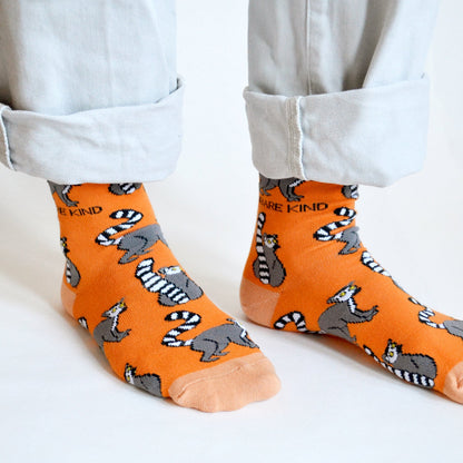 closeup of orange lemur socks on standing model 