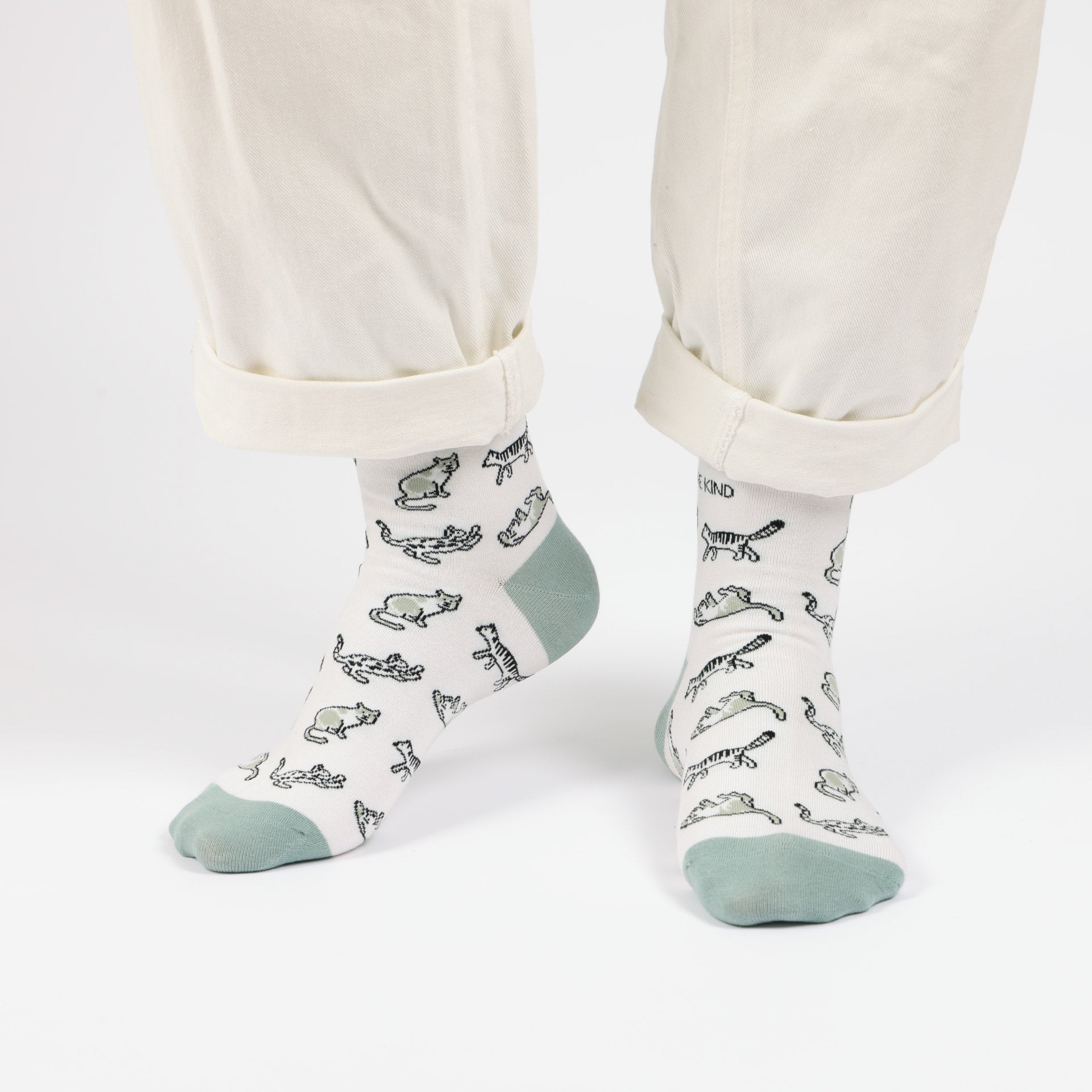 model with white trousers wearing green cat bamboo socks