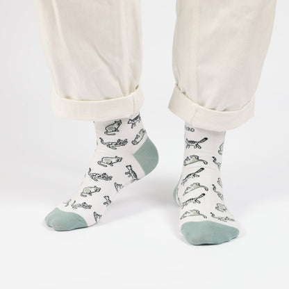 model with white trousers wearing green cat bamboo socks